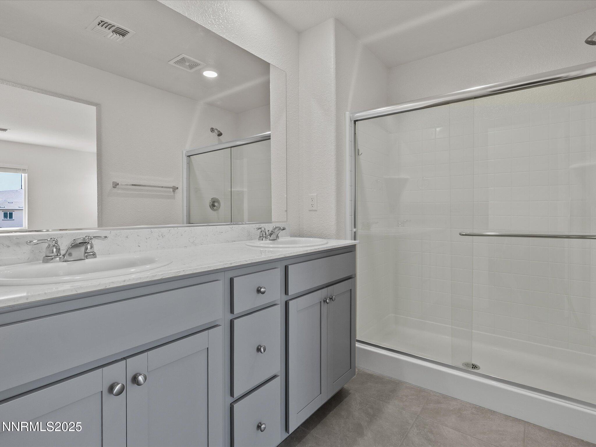 8838 Finnsech Drive Reno, NV 89506 - Photo 28 of 44 a bathroom with double sink and a mirror