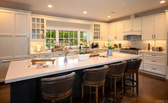 a kitchen with a sink and chairs