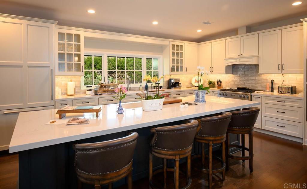 17925 Avenida Alondra Rancho Santa Fe, CA 92067 - Photo 6 of 11 a kitchen with a sink and chairs