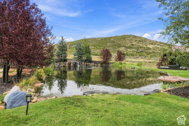 5936 Triple Crown Trail Oakley, UT 84055 - Photo 37 of 57 Expansive pond with a rock-lined edge, integrated waterfall feature, and surrounding mature trees