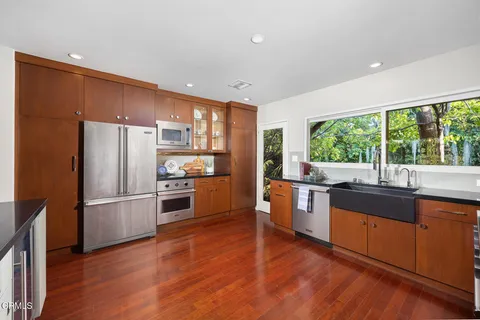 a kitchen with granite countertop a stove top oven sink and cabinets
