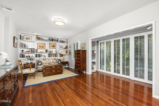a spacious bedroom with wooden floors and a bed