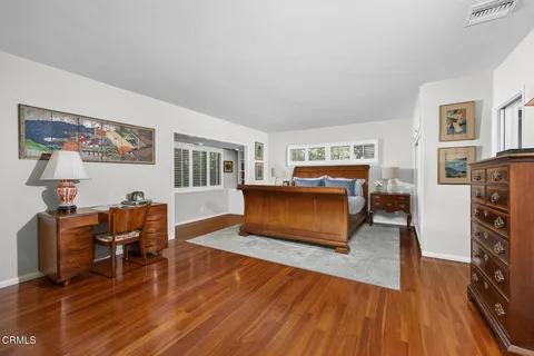 a bedroom with furniture and wooden floor