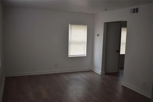 an empty room with wooden floor and closet