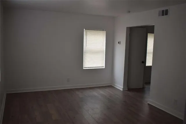 an empty room with wooden floor and closet