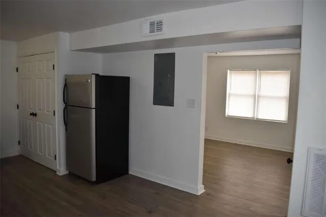 an empty room with wooden floor and a window