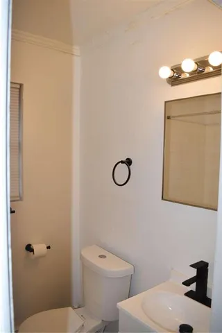 a bathroom with a sink a toilet and mirror