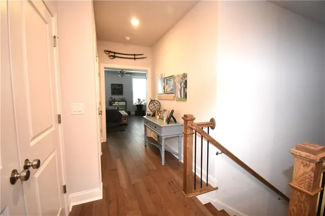 a view of a hallway with wooden floor and staircase
