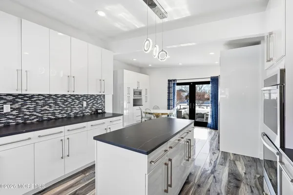 a kitchen with granite countertop a sink stove and cabinets