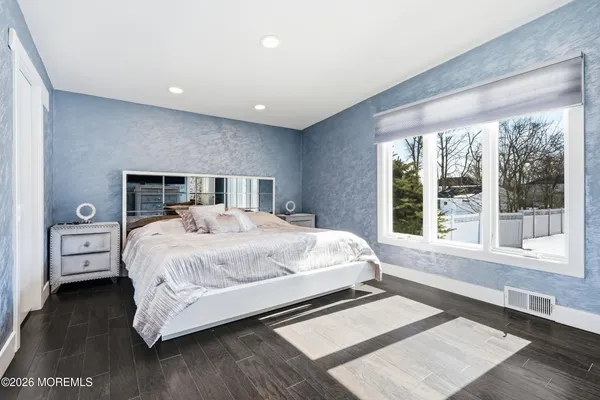 a bed sitting in a spacious bedroom next to a window