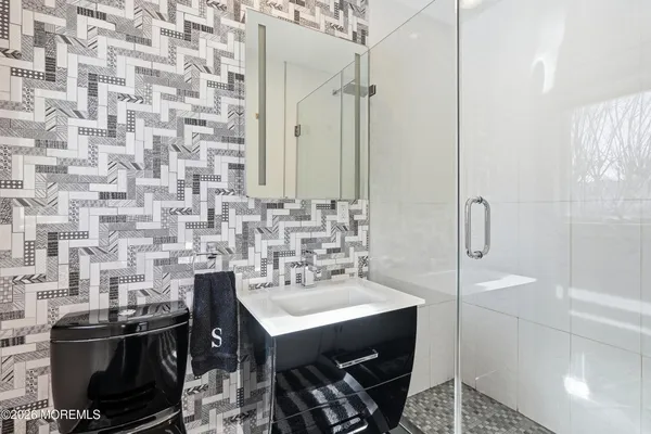 a bathroom with a sink a toilet and shower