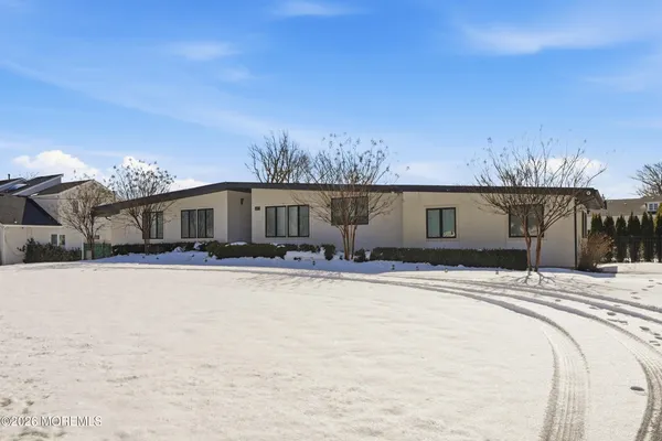 a front view of house with yard and trees in the background