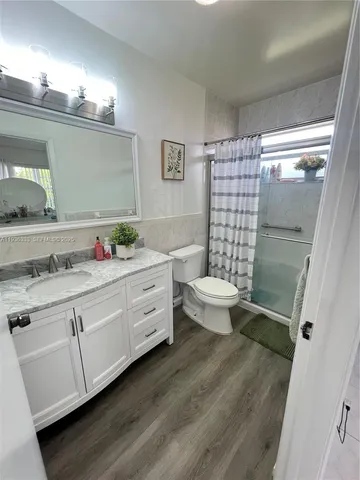 a bathroom with a granite countertop sink toilet and shower
