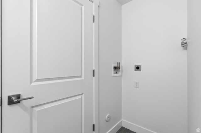 2085 North Main Street, Unit 306 Sunset, UT 84015 - Photo 16 of 18 Utility area featuring a paneled door with brushed nickel hardware, a white laundry hookup box, a dryer vent, and electrical outlets