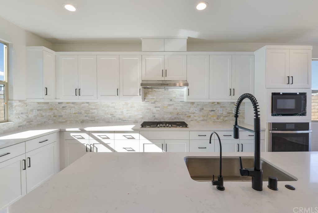 32318 Sonder Way Temecula, CA 92591 - Photo 3 of 18 a kitchen with granite countertop white cabinets and stainless steel appliances