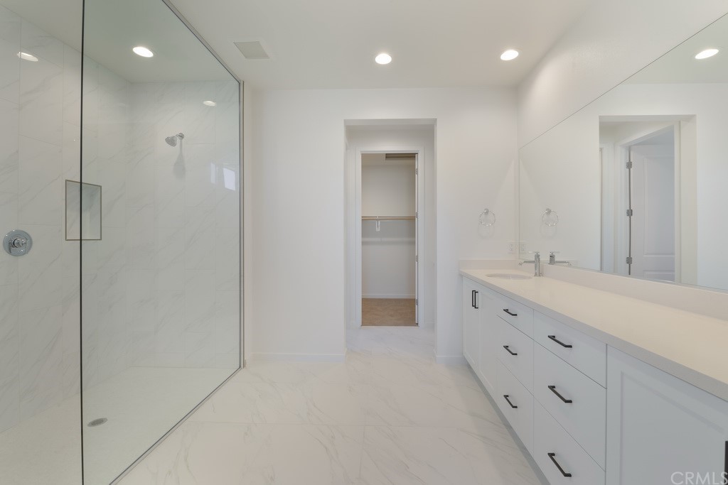32318 Sonder Way Temecula, CA 92591 - Photo 9 of 18 a bathroom with a double vanity sink a large mirror and a shower
