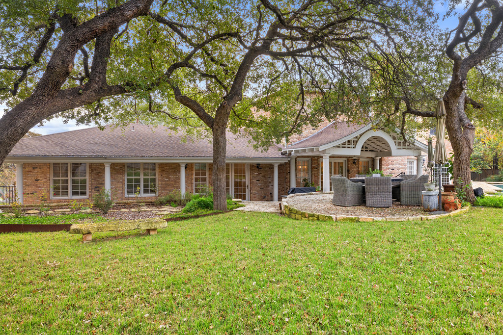 4 Rock Way Cove Austin, TX 78746 - Photo 25 of 26 a front view of a house with swimming pool and porch with furniture