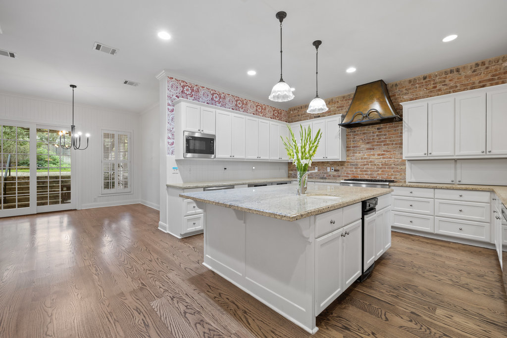 4 Rock Way Cove Austin, TX 78746 - Photo 9 of 26 a large kitchen with granite countertop a stove a sink a center island and wooden floor