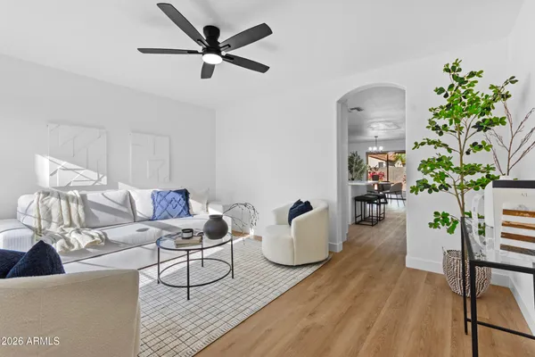 a living room with kitchen island granite countertop furniture a rug kitchen view and a window