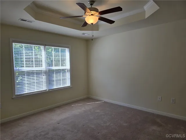 an empty room with a window and a ceiling fan