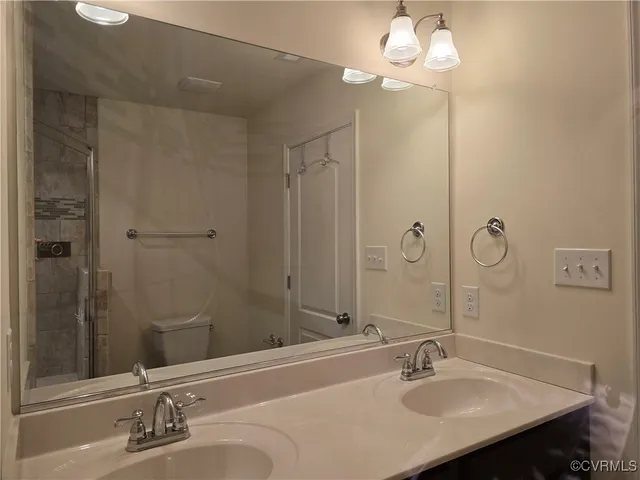 a bathroom with a sink a light fixture and a mirror