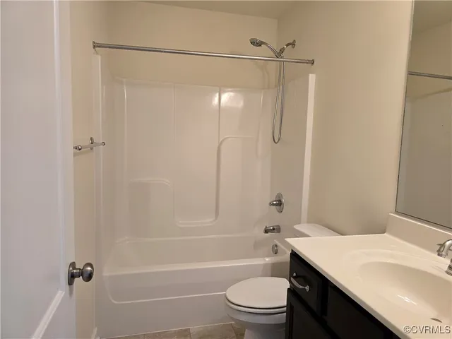 a bathroom with a granite countertop bathtub shower sink vanity and toilet