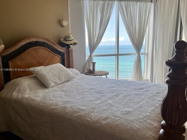 6767 Collins Avenue, Unit 1107 Miami Beach, FL 33141 - Photo 8 of 10 a bedroom with a bed and a large window