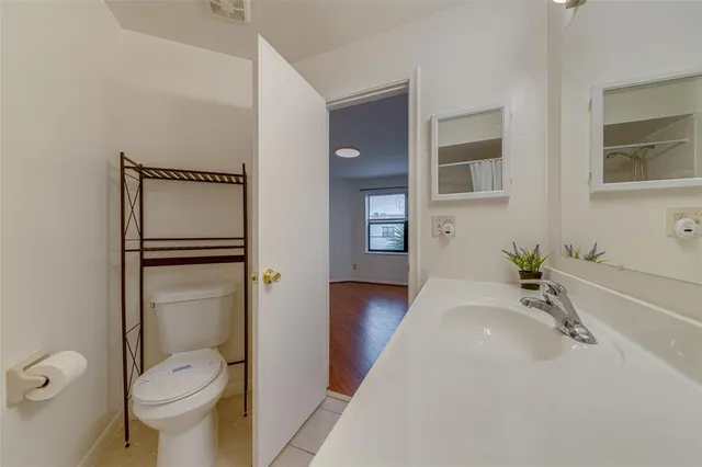 a bathroom with a granite countertop toilet sink and mirror