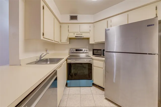 a kitchen with a stove top oven and refrigerator