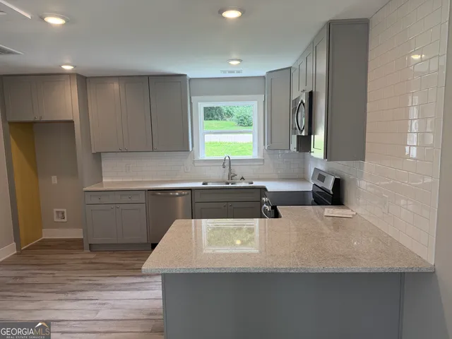 a kitchen with a sink a window and cabinets