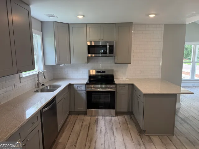 a kitchen with stainless steel appliances granite countertop a sink stove and refrigerator