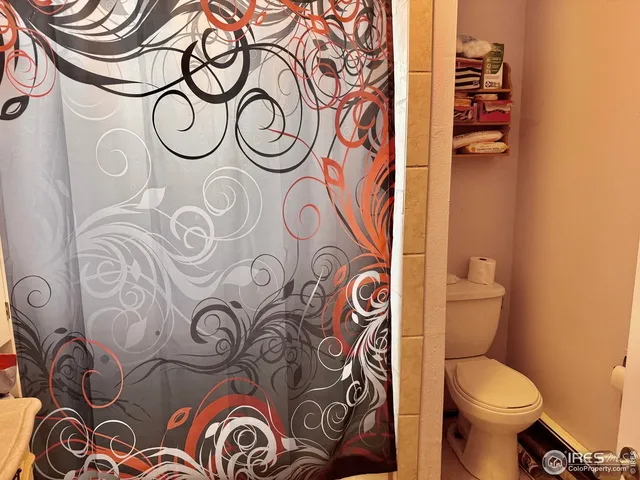 a bathroom with a toilet and a shower curtain
