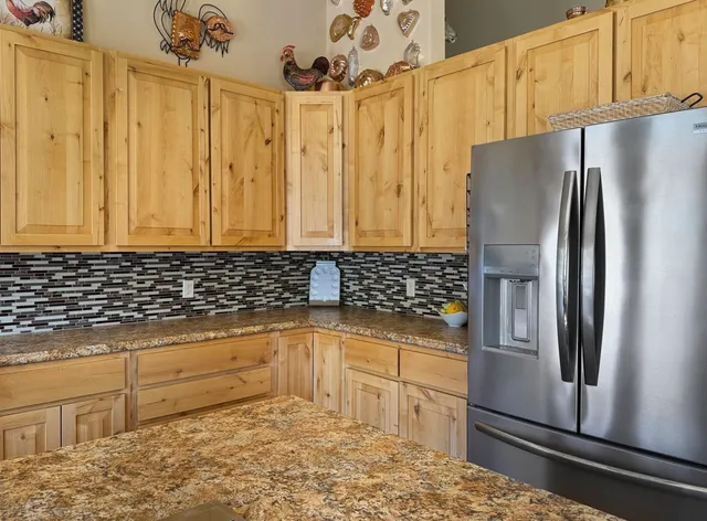 a kitchen with stainless steel appliances granite countertop a refrigerator and a sink