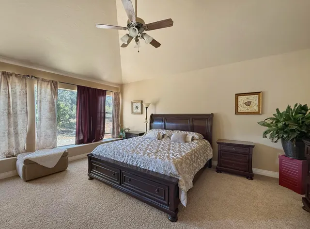 a spacious bedroom with a bed a couch and a chandelier