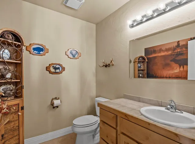a bathroom with a granite countertop toilet and a sink