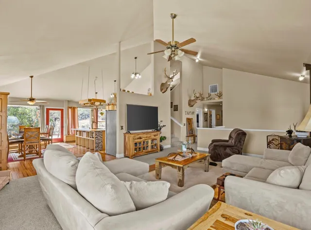 a living room with furniture a flat screen tv and a large window