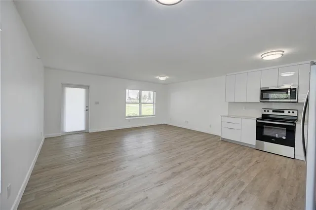 a view of a kitchen with an empty space wooden floor and a window