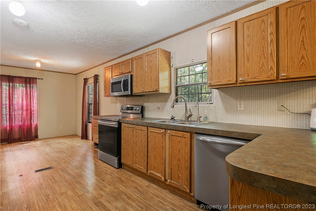 4759 Darroch Road Lillington, NC 27546 - Photo 14 of 50 a kitchen with stainless steel appliances granite countertop a sink stove and microwave