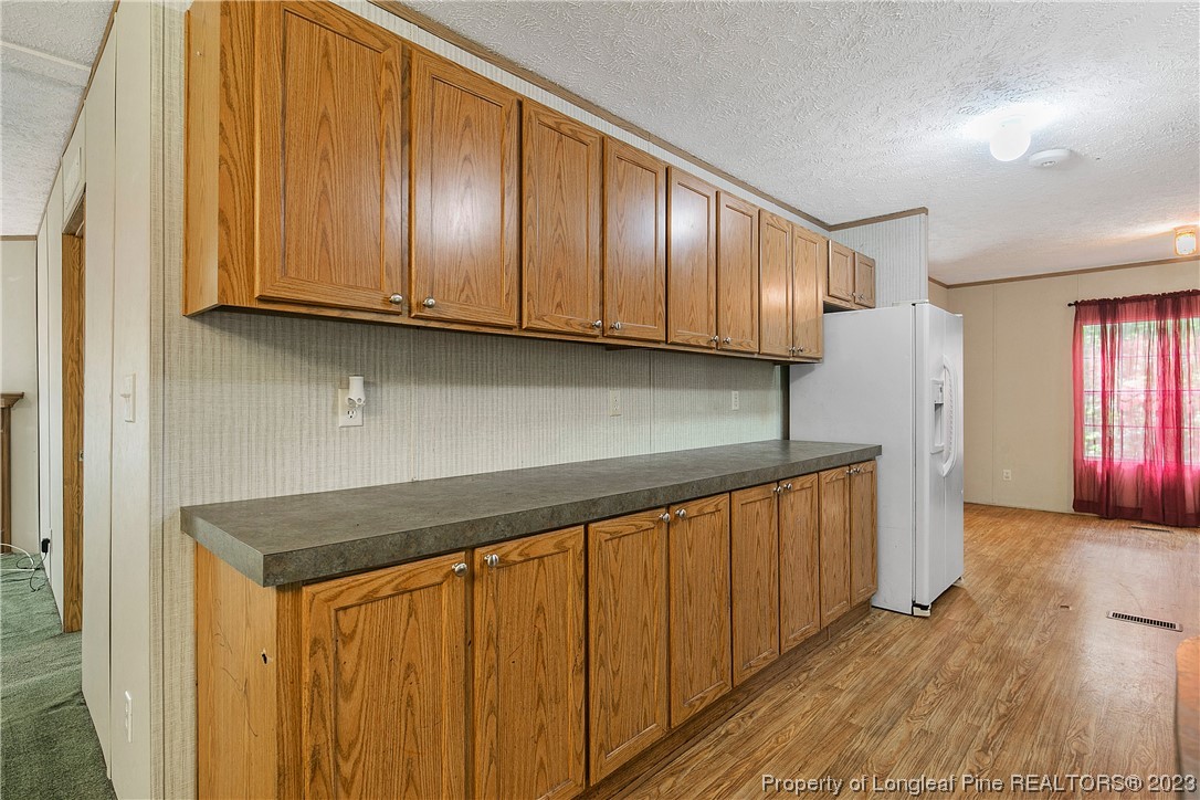 4759 Darroch Road Lillington, NC 27546 - Photo 16 of 50 a kitchen with granite countertop wooden cabinets stainless steel appliances and a refrigerator