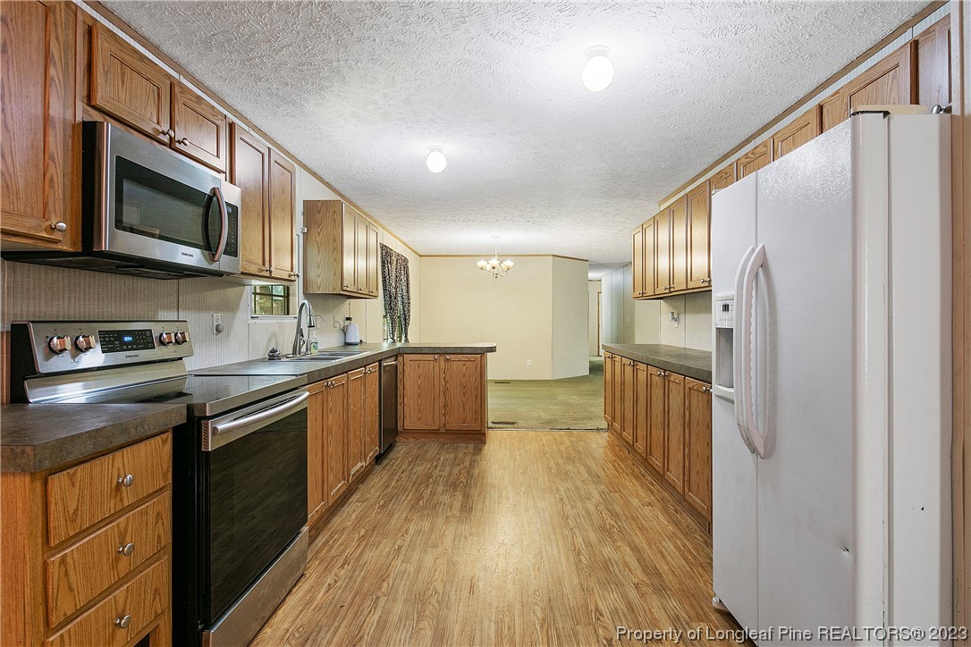 4759 Darroch Road Lillington, NC 27546 - Photo 18 of 50 a kitchen with stainless steel appliances granite countertop a refrigerator a stove top oven a sink and dishwasher