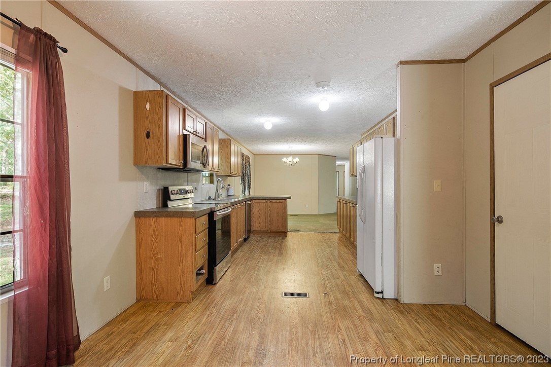 4759 Darroch Road Lillington, NC 27546 - Photo 21 of 50 a view of kitchen with stainless steel appliances granite countertop a refrigerator a stove a sink and dishwasher with wooden floor