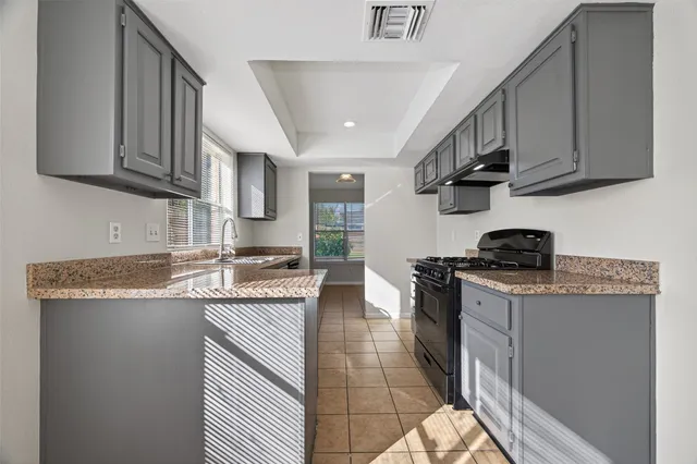 a kitchen with granite countertop a sink stainless steel appliances and cabinets