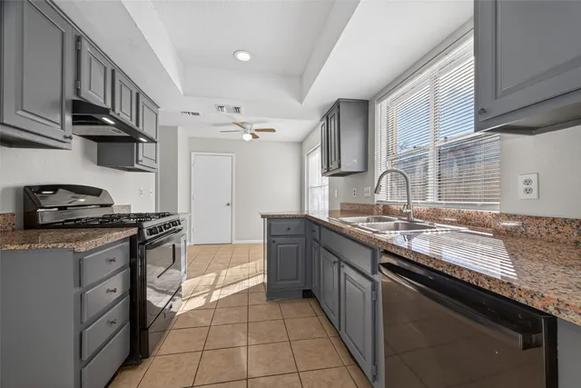 a kitchen with granite countertop a sink and a stove
