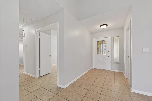 an empty room with windows and fireplace