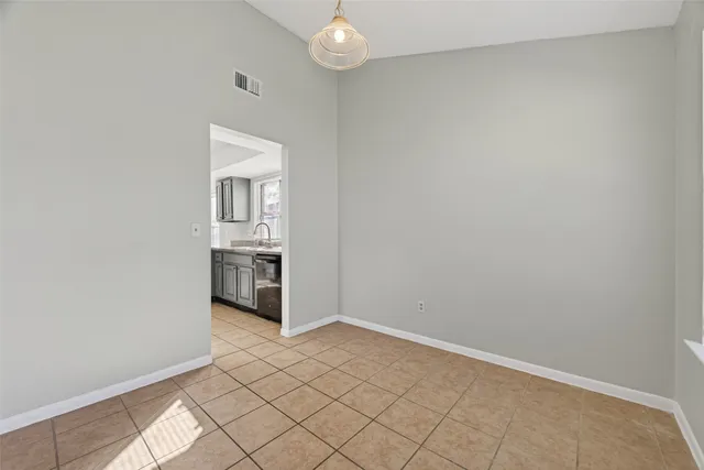 an empty room & kitchen space with a fireplace