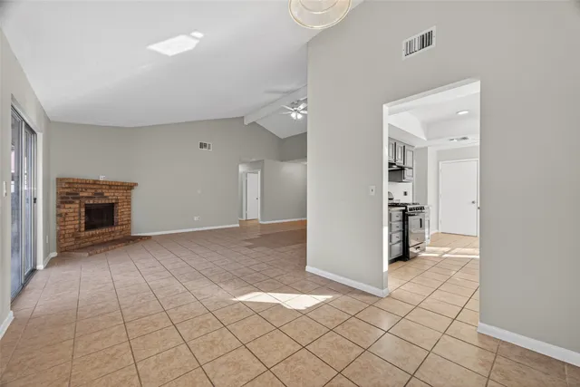 a view of an empty room with window and fire place