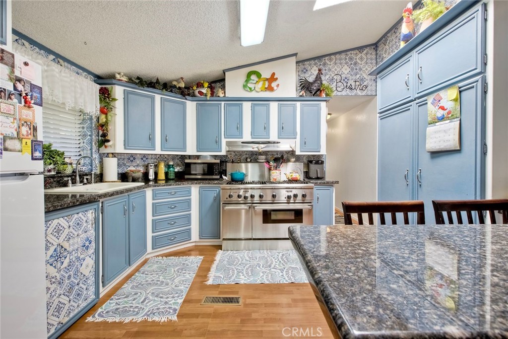 34370 The Farm Road Wildomar, CA 92595 - Photo 17 of 31 a kitchen with stainless steel appliances granite countertop a stove a sink and a microwave