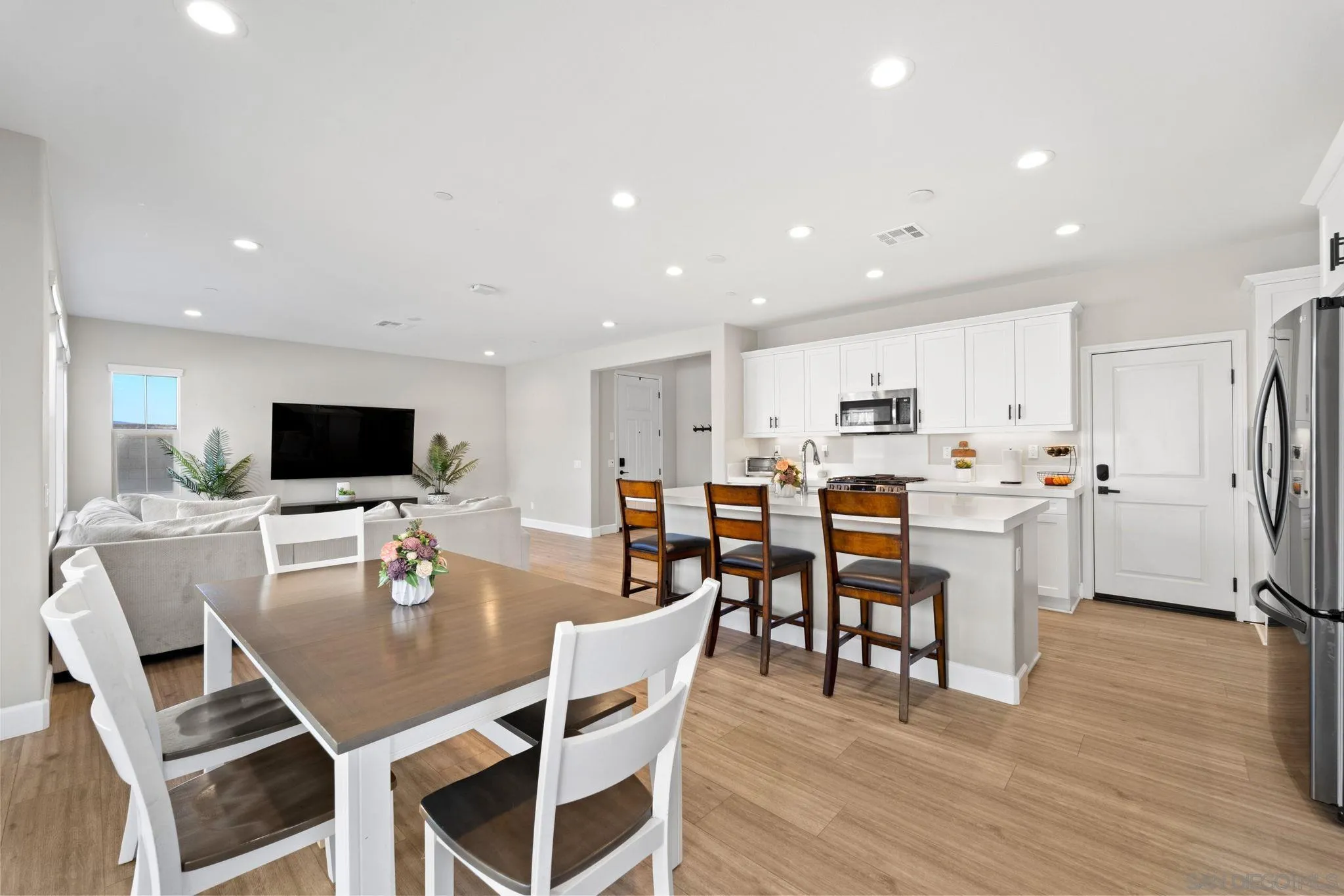 1279 Camino Prado Chula Vista, CA 91913 - Photo 12 of 38 a dining room with stainless steel appliances kitchen island granite countertop a dining table chairs and a refrigerator