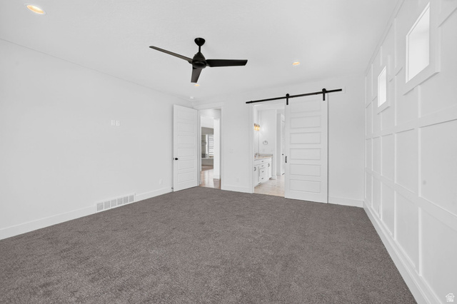 1002 West Temple Rim Lane Payson, UT 84651 - Photo 28 of 68 Spacious room featuring a decorative accent wall with recessed square panels, dark gray carpeting, and a modern black ceiling fan