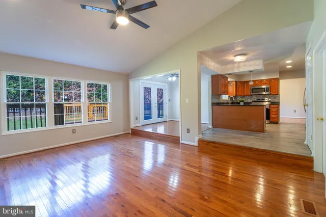 a view of an empty room with kitchen and a window
